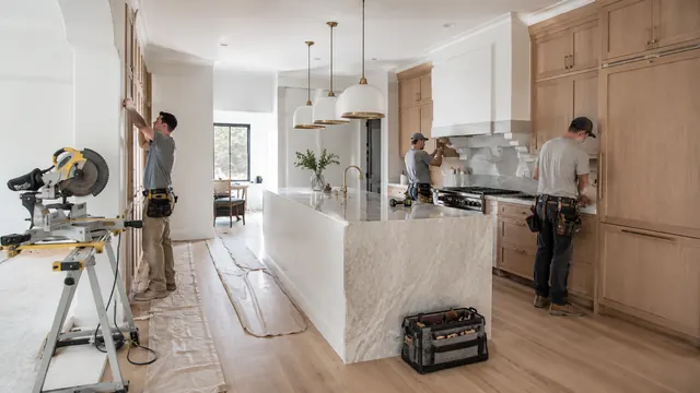 Crew installing custom cabinets and a marble island in a Utah kitchen